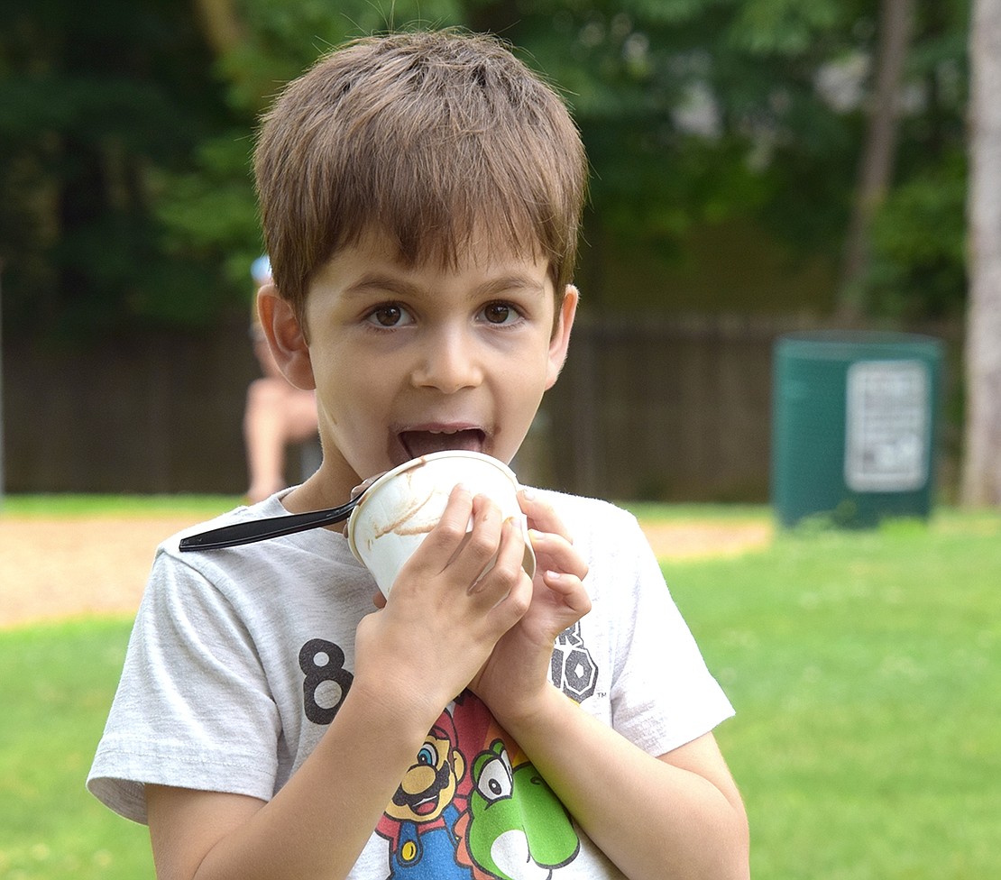 Meadowlark Road resident Theo Kusovitsky forgoes the spoon as he enjoys some ice cream at Pine Ridge Park on Friday, July 7, during Rye Brook’s first Ice Cream Friday of the year. Free ice cream will be available at the park every Friday in July from 6 p.m. to 7:30 p.m. The event features ice cream, music and a bounce house. A screening of the movie “Lightyear” followed last Friday’s event.
