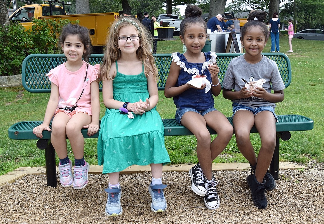 Betsy Brown Road resident Bianca Ciardullo (left), Tamarack Road resident Sara Levine, a Ridge Street Elementary School rising fourth-grader, and Nella Lane, Port Chester, residents Jacelyn and Cailey Miranda sit on a bench while eating their ice cream.