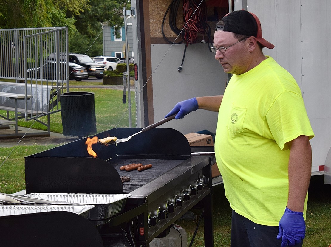 Rye Brook Highway Department employee Joe Orlando grills hamburgers and hotdogs to serve at the village’s Ice Cream Friday at Pine Ridge Park.