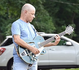 The rest of the band takes a back seat while John Scavelli shreds a solo with his guitar.