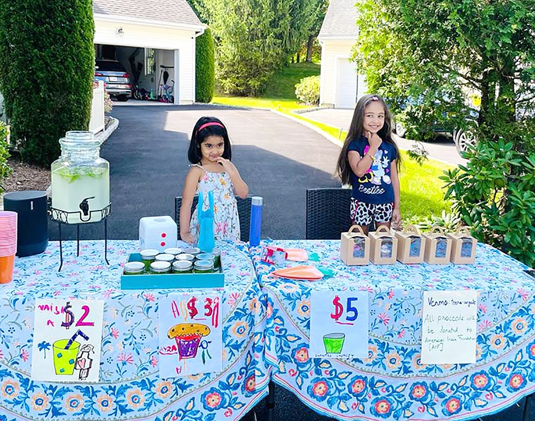 Ayra Chandarana, 3, and Naisha Battiwala, 4, sell cupcakes and lemonade in their BelleFair community to raise money for the American India Foundation on Saturday, July 22.