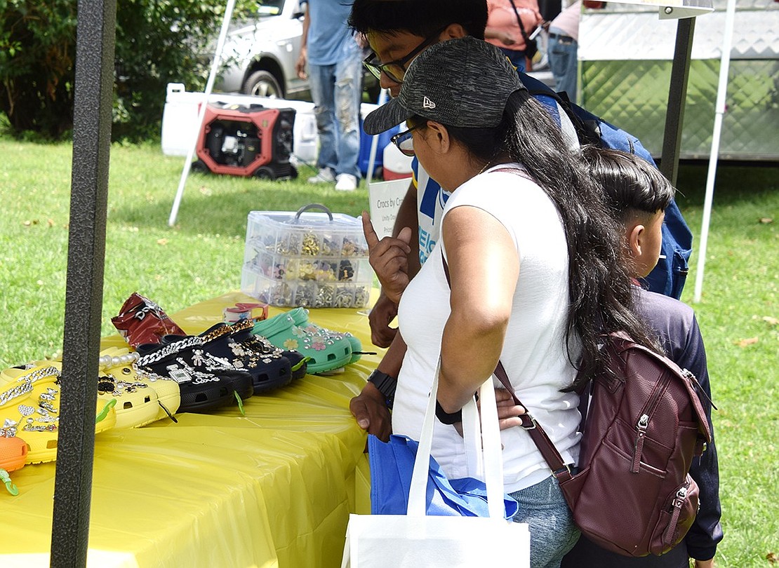 Basketball wasn’t the only draw to Unity Day. Local vendors attended to display their goods, too. Port Chester residents Maria Guaman (front) and Adrian Pomavilla browse decorative Crocs made by Felicia Craft at the event.