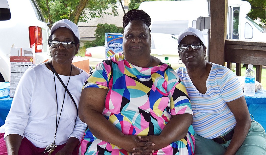 Traverse Avenue residents Judy (left) and Janet Rodriguez sit around Stamford, Conn. resident Elaine Blackburn to pose for a picture while enjoying a meal at Unity Day.