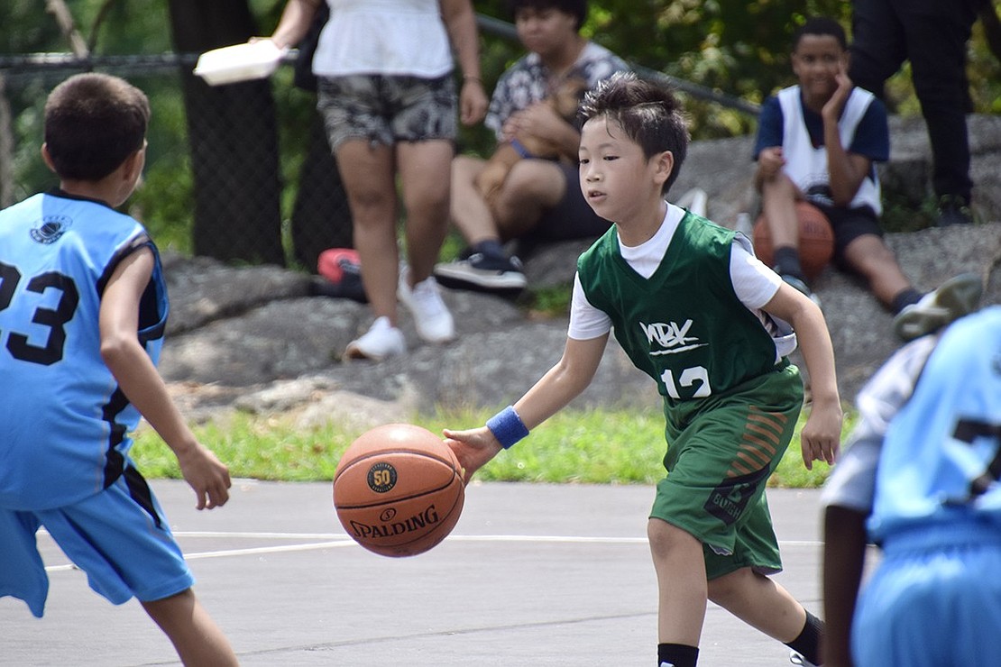 Tuckahoe 9-year-old Shun Nitta dribbles a basketball past his opponents.