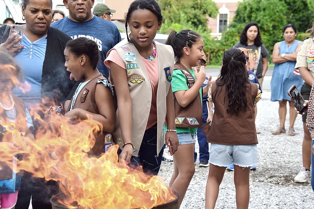Port Chester Middle School eighth-grader Vanessa Jones, a member of Girl Scout Troop 1235, retires an American flag collected from St. Mary’s Cemetery by burning it in a ceremony outside the Knights of Columbus Hall at 327 Westchester Ave. on Thursday, Aug. 17. According to U.S. Flag Code, the proper way to retire a flag is by burning.