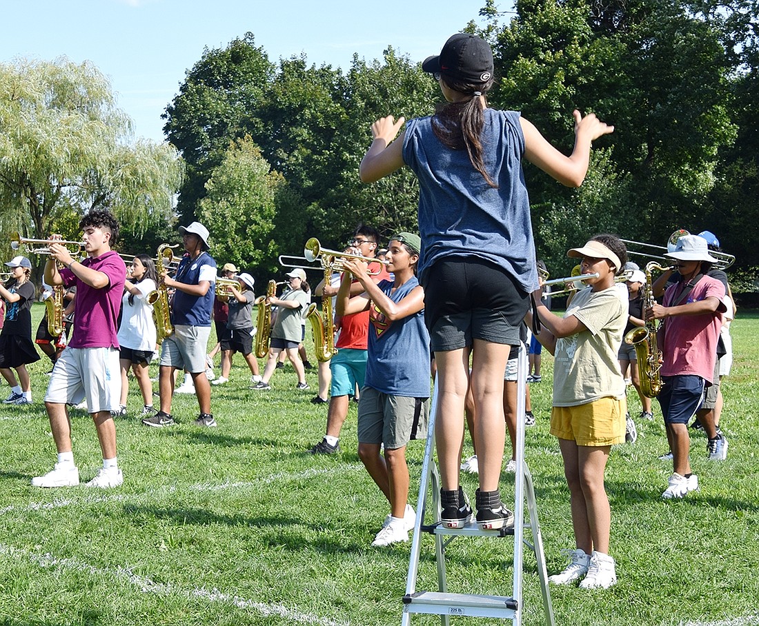 Senior Drum Major Keren Castellanos positions herself on the corner of the field to help keep the pace through the art of conducting while marchers run through a movement of “New World Symphony,” their 2023-24 show, during Band Camp at Crawford Park on Tuesday, Aug. 22.