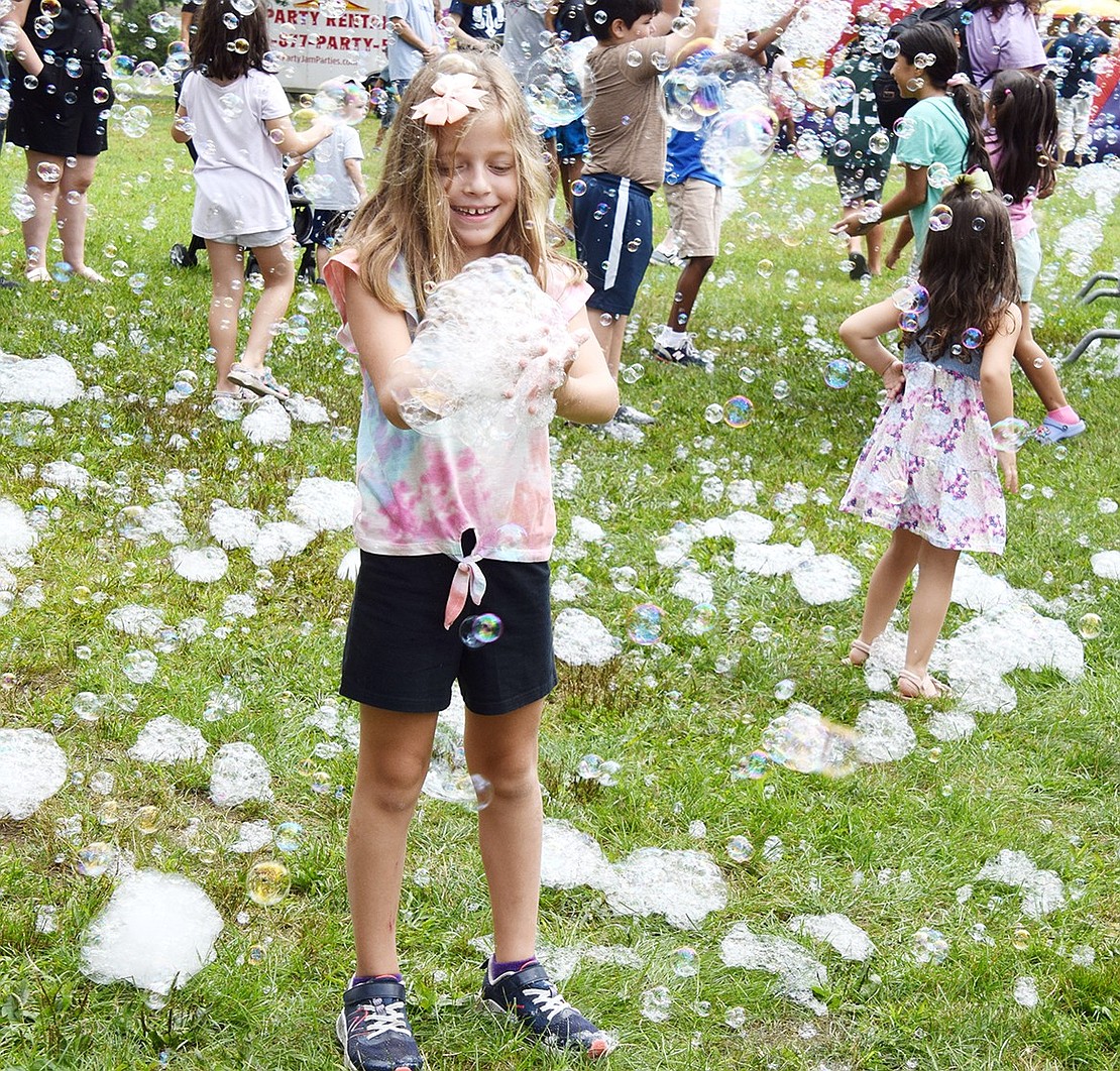 Eight-year-old Cassandra Johnson of Valley Cottage, daughter of Edison and Park Avenue elementary schools music teacher Michael Johnson, delights in manipulating a huge handful of bubbles.