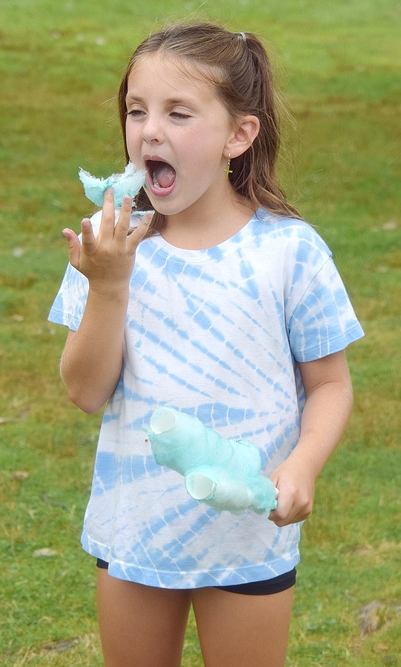Eight-year-old Charlie Steers of Greenwich takes a bite of cotton candy from the Port Chester-based Steph’s Creations booth.