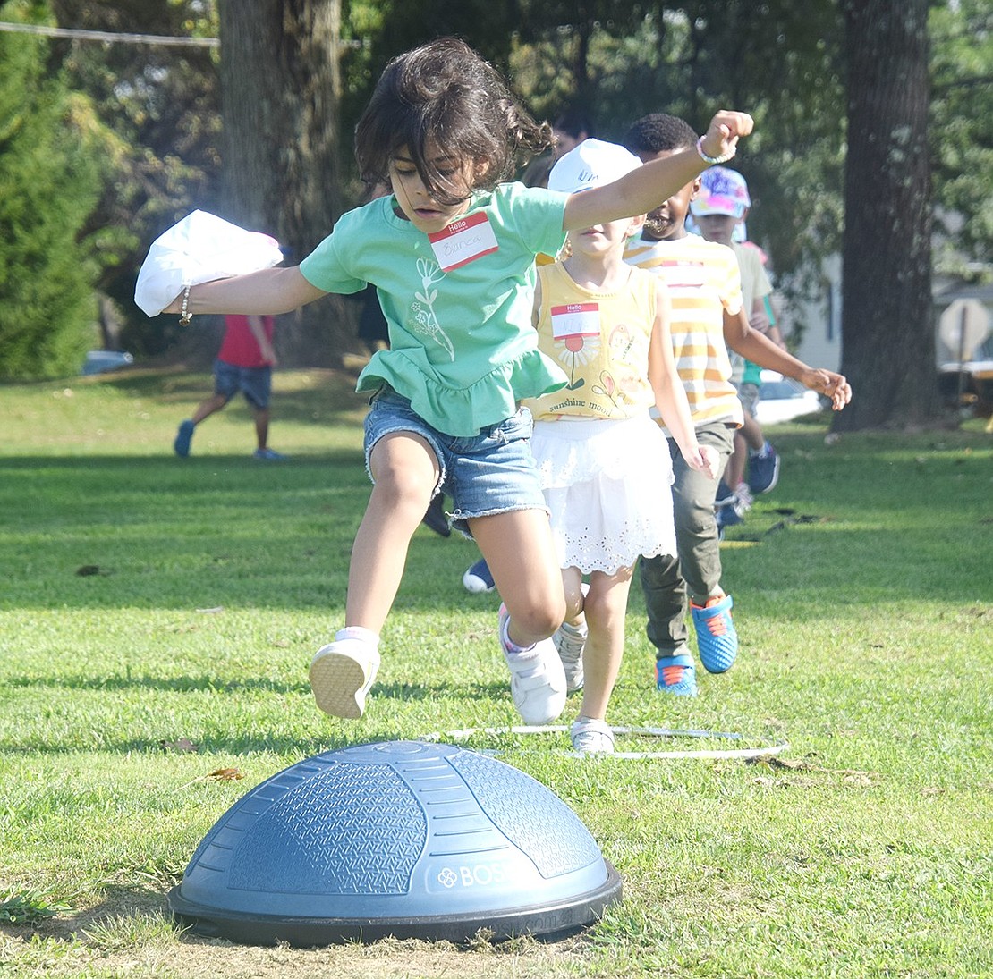 Bianca Ciardullo, a future student in Karen Johnson’s class, lets her competitive edge shine as she hops over a balance trainer set up on the route of an obstacle course.