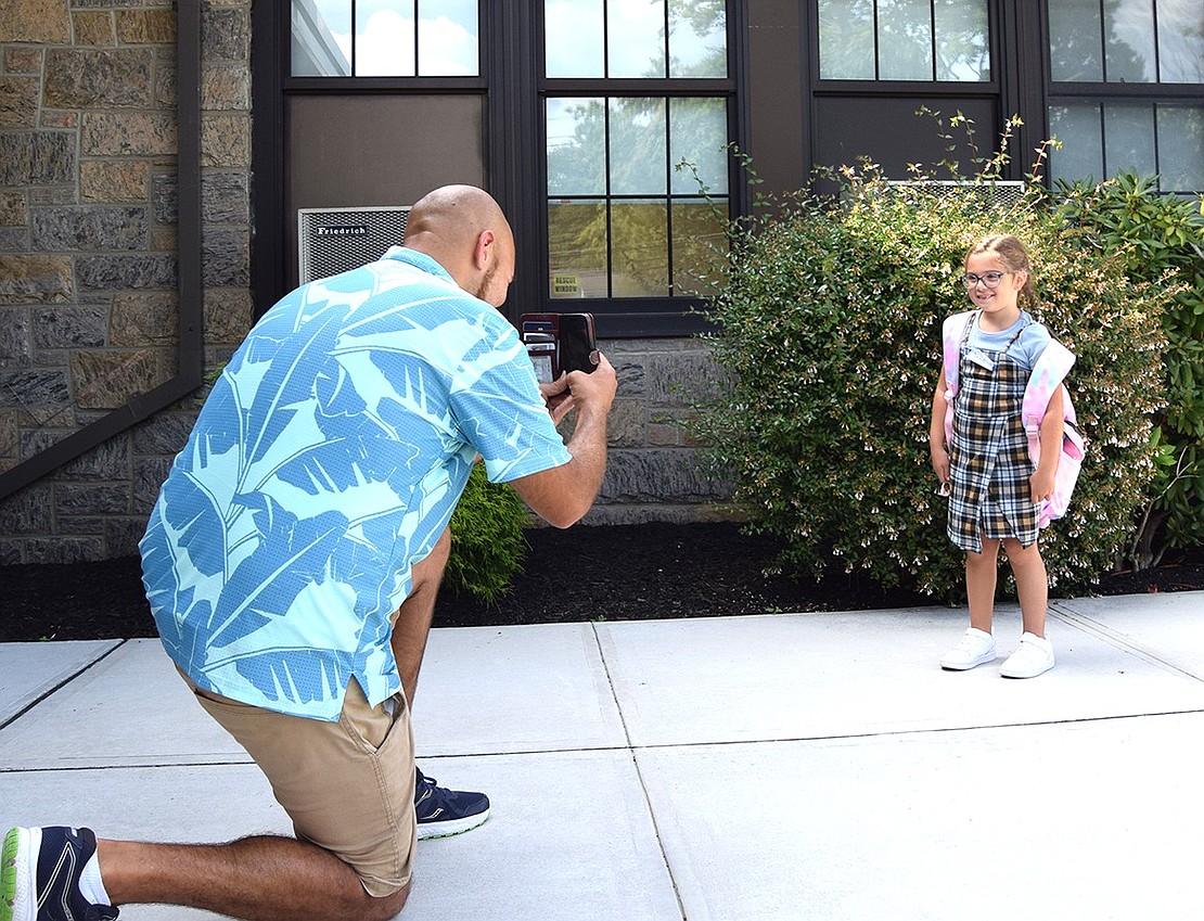 Zachary Dore takes a commemorative photo of daughter Annie after her first day of second grade.