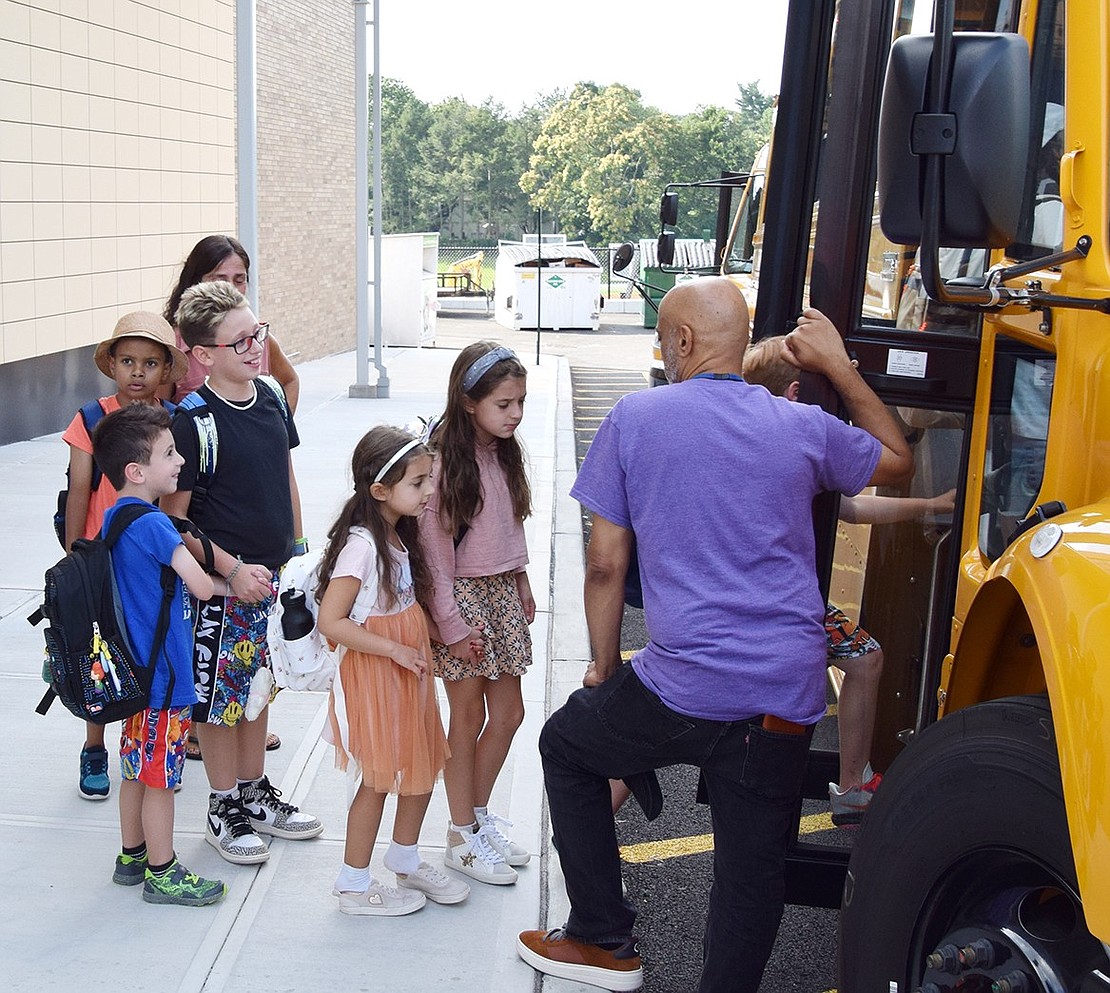 Tor Snyder (right), a Ridge Street Elementary School employee, speaks with a group of students as they head home after the first day of school on Tuesday, Sept. 5.