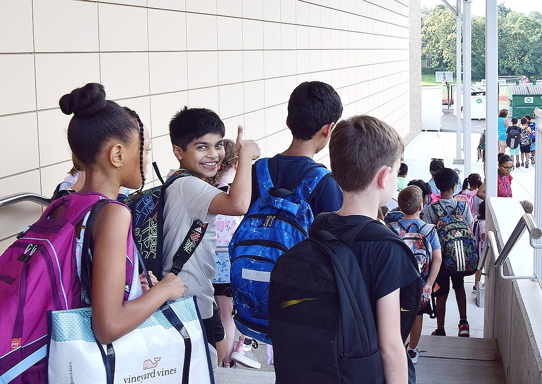 Students are in good spirits as they make their way to the bus after a long first day of school.