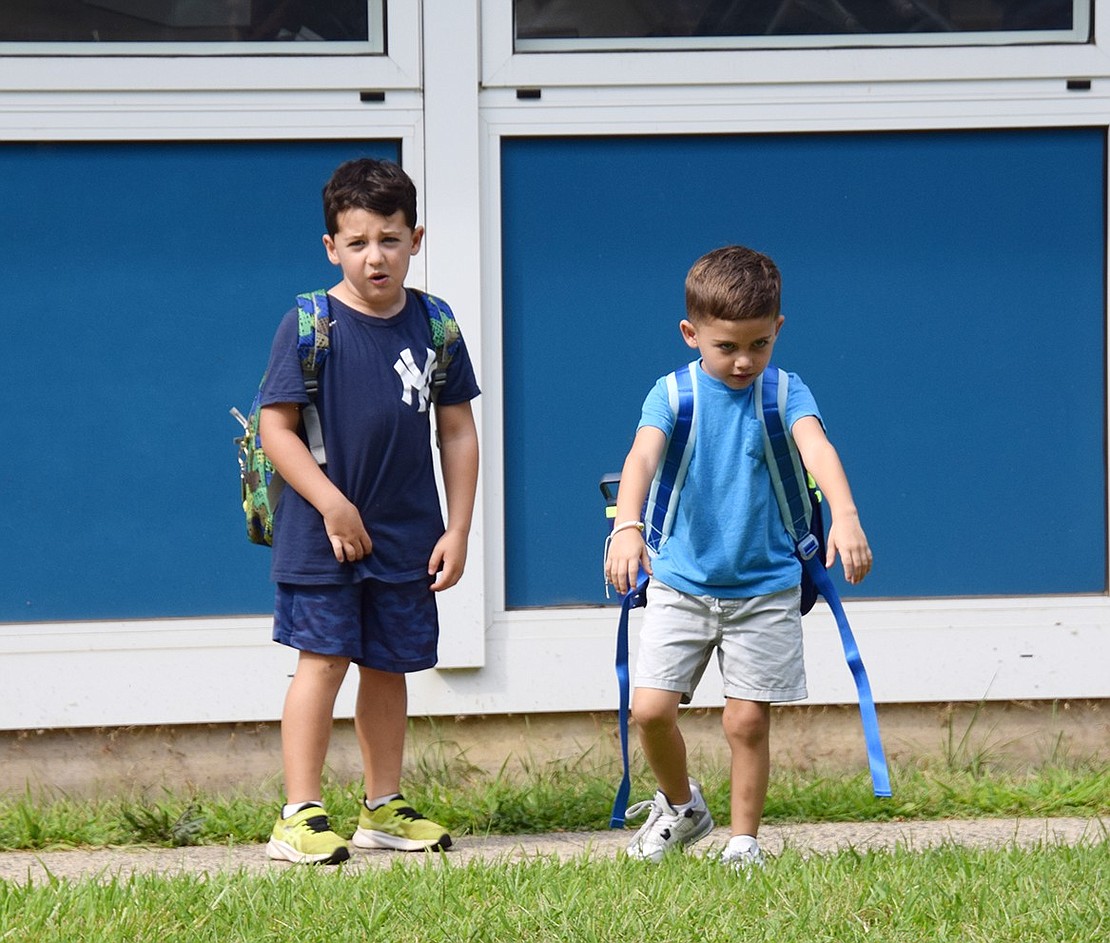 Kindergarteners Harrison Burt (left) and Mikey Zanzano blow off some steam as they play after school.