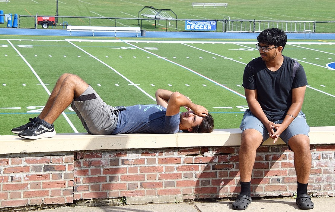 Senior Orhan Eski (left) rests in the 80-degree sun with junior Shawn Cheriyan.