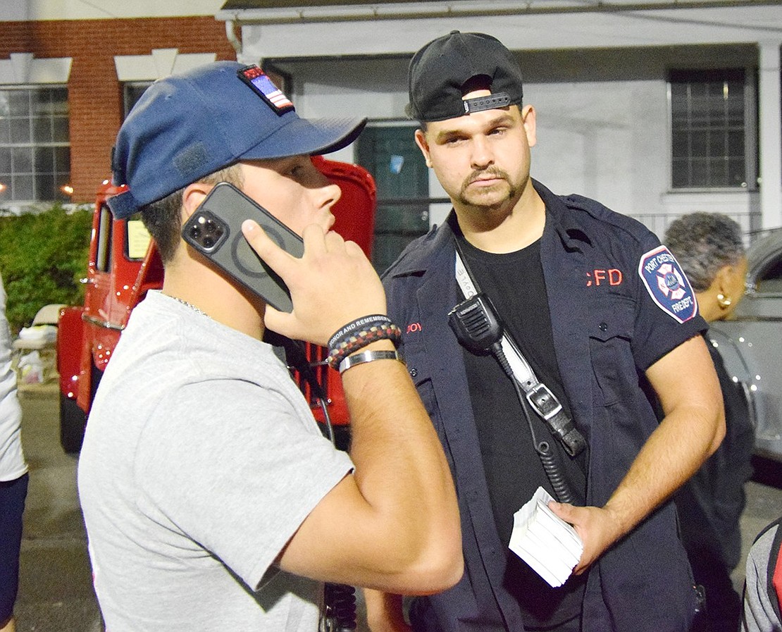 Port Chester volunteer firefighters P.J. Cambriello (left) and Brendan Doyle spent the night selling raffle tickets to fundraise for the fire department.
