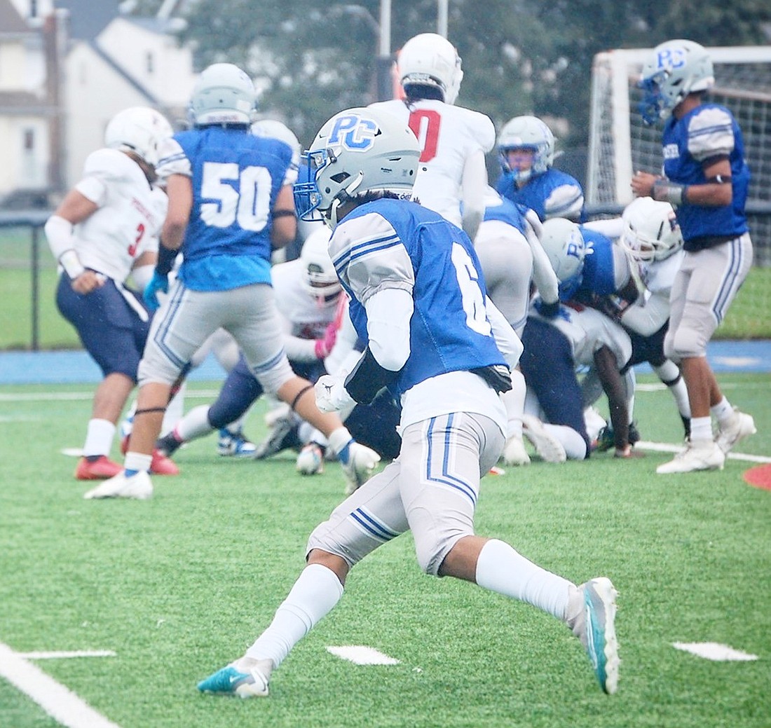 Port Chester’s John Delcid (#6) runs out to make a block versus a Peekskill defender in last Saturday’s 38-8 loss to Peekskill under trying weather conditions.