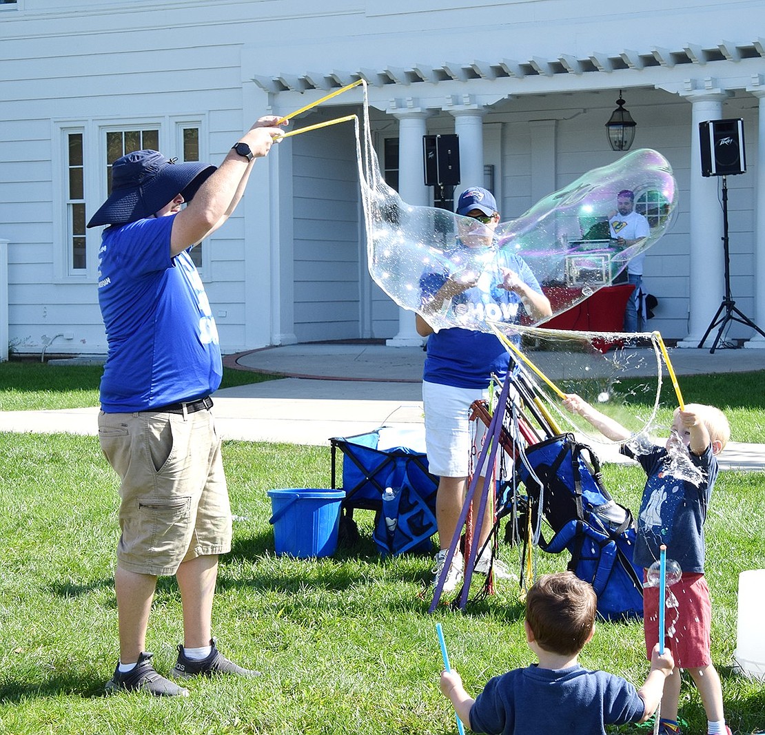 Originally from Rye Brook, four-year-old Eli Reich (right), currently of Armonk, shows off his bubble making skills with Scotty Kazan, founder of My Bubble Guy Show, at the Dashing for Dylan Fun Run.