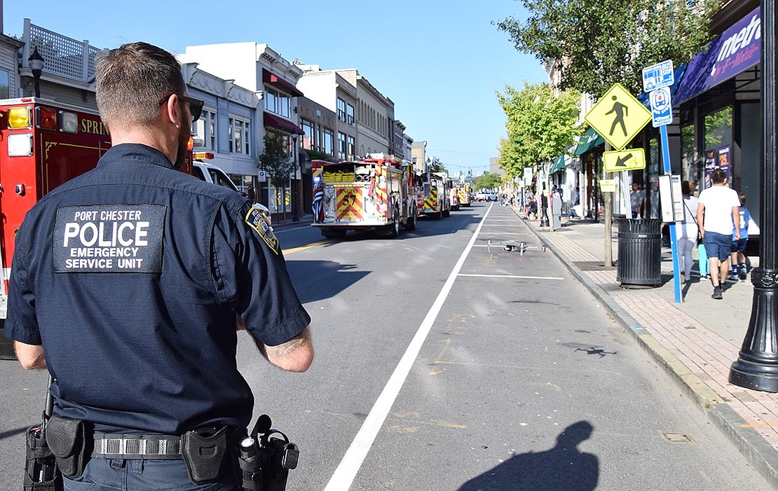 Port Chester Police Officer Ken Manning pilots a remote-controlled drone on North Main Street, capturing footage of the parade from the sky.