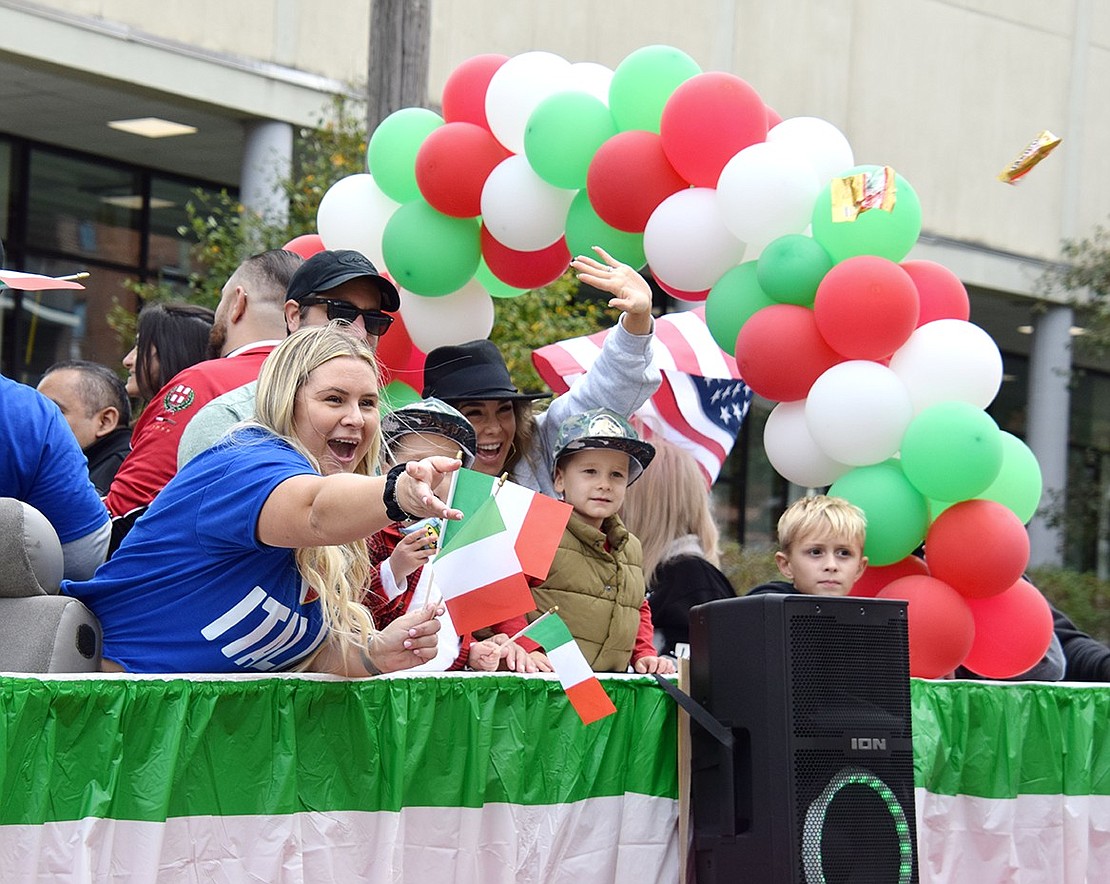 The Marini’s Deli float that followed the grand marshal—Ricky Marini, owner of the store—parties during the annual Columbus Day Parade on Sunday, Oct. 8. In festive fashion, Sabrina Marini tosses candy toward the sidewalk filled with spectators along the procession’s Westchester Avenue route.