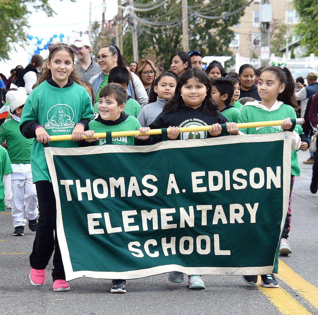 Edison School students proudly represent their school by working together to present the banner. From the left: fifth-grader Kathryn Melon, fifth-grader Luke Melon, fourth-grader Carla Zapata and third-grader Gianna Pesantez.