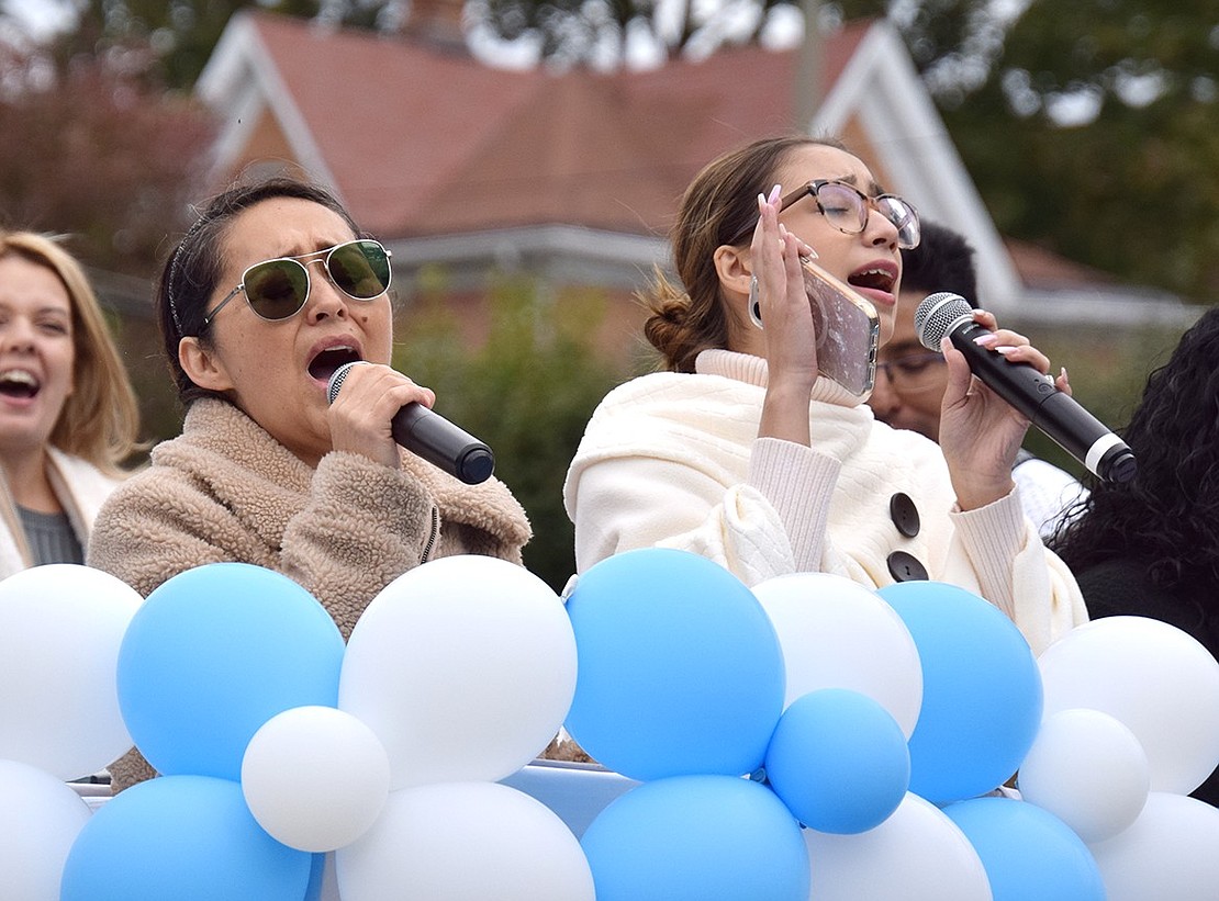 Riding on the float representing Segunda Iglesia Pentecostal Juan 3:16, a Poningo Street church, Port Chester residents Fabiola Carreto (left) and Rebecca Quintana sing to the heavens.