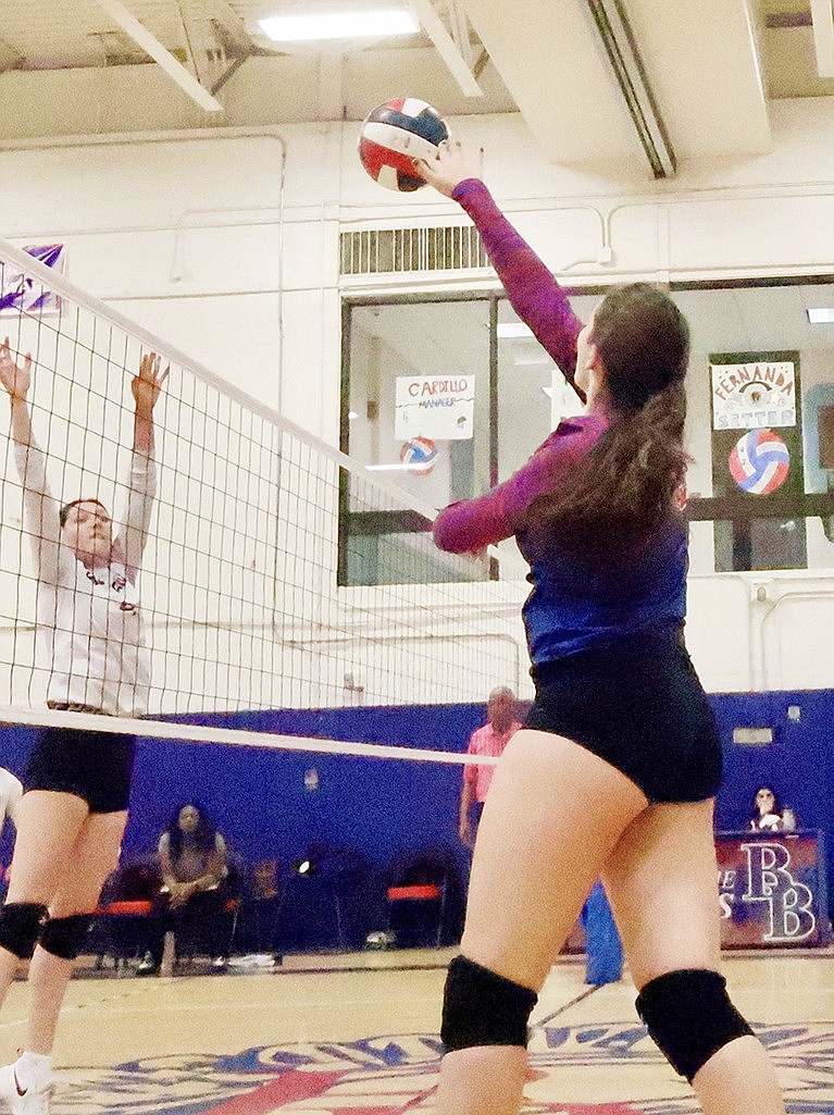 Madeline Hirsch tips the ball over the net in hopes of scoring in the Monday, Oct. 16 home game vs. Sleepy Hollow, a 3-1 victory for the Lady Trojans.