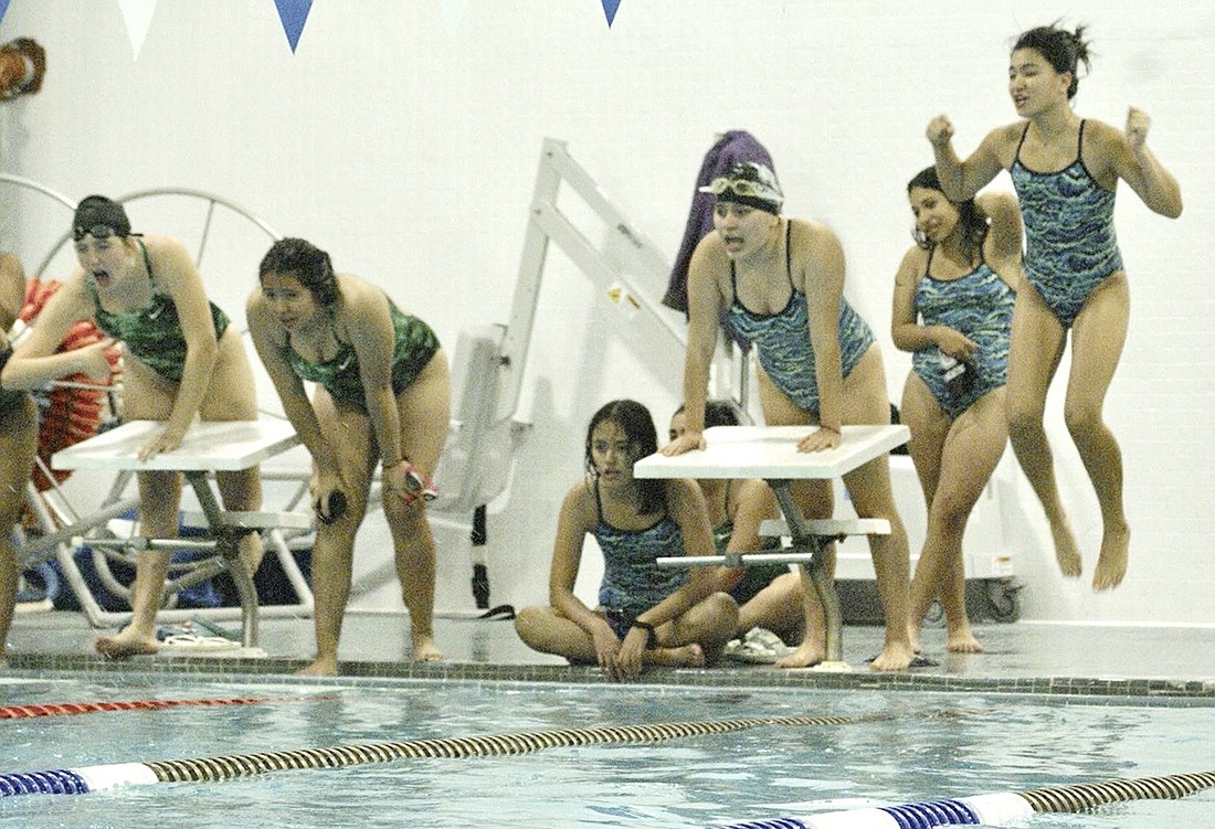 Port Chester Lady Rams swim team members Brenda Cordova (sitting), Ashley Zapata (standing at the block), Estefania Bautista (standing in the back) and Morgan Saunders (jumping for joy) cheer on their fellow swimmer Chenoa Marquez performing in the 200-freestyle relay on Monday, Oct. 16 in their Carver Center home pool. Despite losing the overall meet to Woodlands, the Lady Rams won that event and four others.