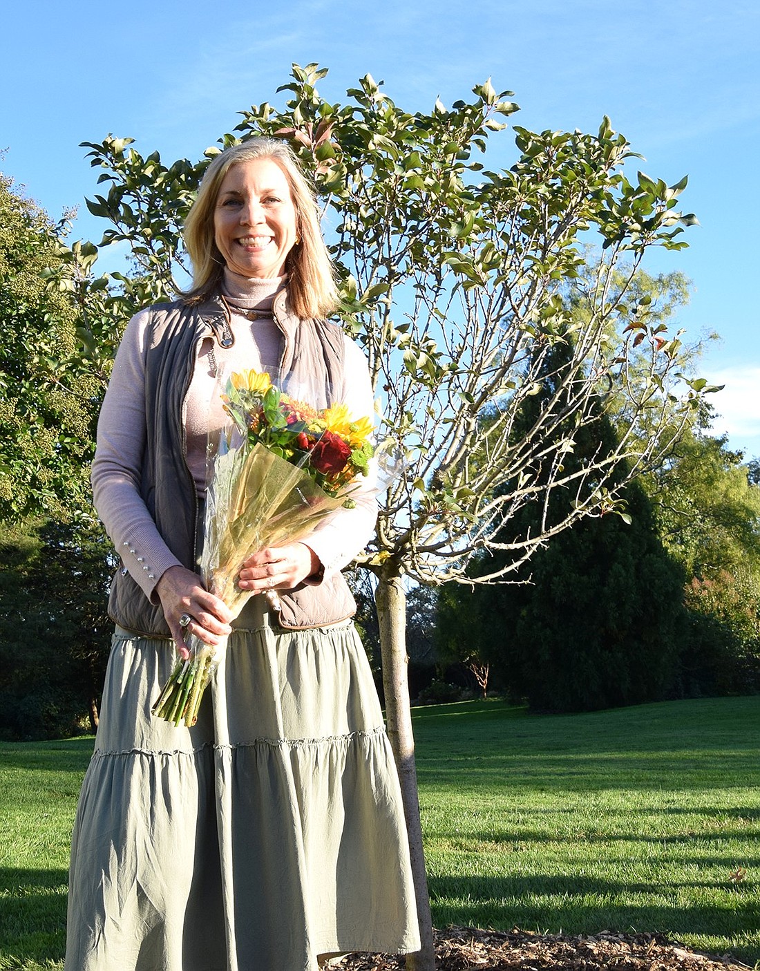 Laura Klein, a former Rye Brook resident who recently moved to Bedford, stands by a royal gem crabapple tree that was planted in her honor due to the work she did as a leader of the Friends of Crawford Park on Friday, Oct 13. The tree has a plaque at its base that reads: “With gratitude to Laura Klein for her 20 years of dedication, leadership, and inspiration beautifying the park.”