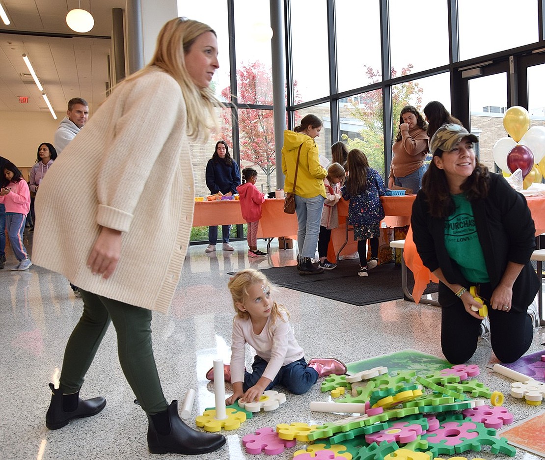 Blind Brook Student Assistance Counselor Monique Tricarico (left) and her daughter, Taylor, check out a plant building activity with Jessica Wang, a pre-school director with the Purchase Children’s Center.