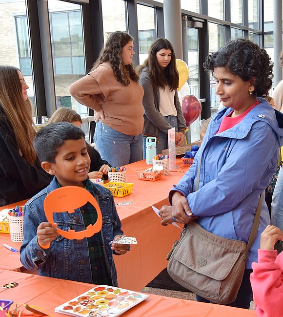 After making good use of the arts and crafts table, Ridge Street School student Aarav Bajaj, 7, shows off a pumpkin he made to his mom Shaila.