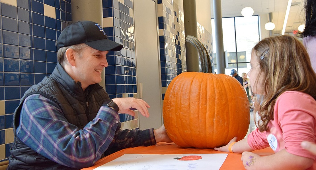 Blind Brook Superintendent Dr. Colin Byrne invites first-grader Chloe Crasper to guess the weight of a large pumpkin at the annual PTA-sponsored Fall Fest on Saturday, Oct. 14. The event was held indoors at Ridge Street School due to rainy weather, but that didn’t stop families from enjoying the day.