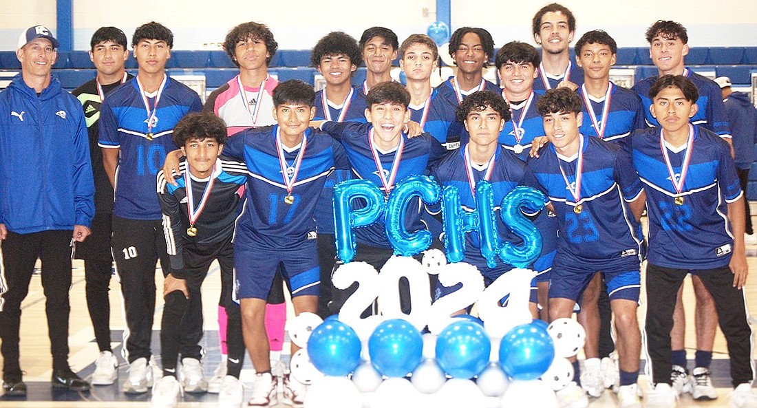 Port Chester boys’ soccer team seniors pose for a photo with coach John Cafaldo at the end of their senior ceremony.