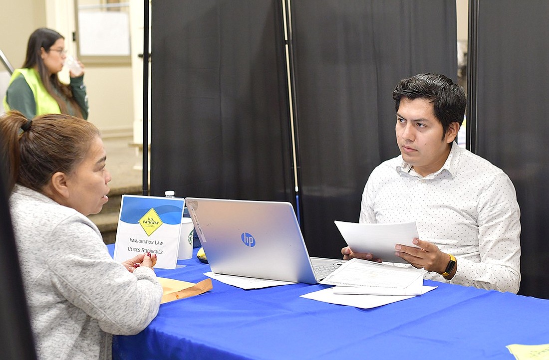 Ulices Rodriguez (right), a lawyer for the nonprofit Make the Road New York, helps an attendee of a free immigration legal clinic that was held at the Port Chester-Rye Brook Public Library on Saturday, Oct. 14. The clinic offered advice to the immigrant community on a variety of topics.