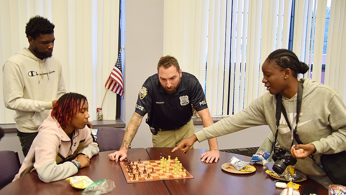 Josiah “Jojo” Jones (left), 19, Elise Thomas, 16, and Nagare Jones, 16, all Port Chester residents, work together to come up with the best move against Port Chester Police Officer Ken Manning at An Evening of Chess, an event hosted by the Village’s Youth Bureau, its Grandpas United program and the Port Chester Police Association on Friday, Oct. 20, at the Port Chester Senior Community Center on Grace Church Street.