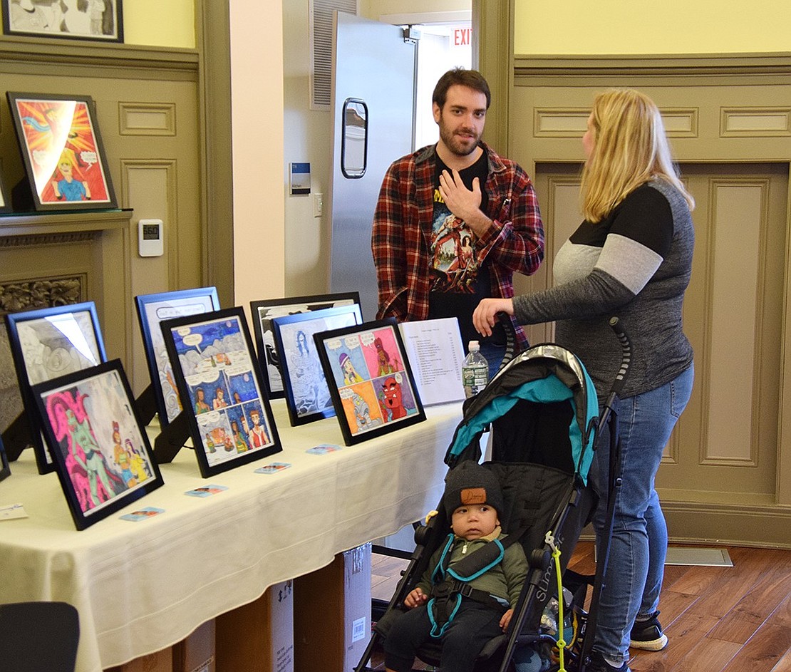 Port Chester cartoonist Gregory Maggi speaks with Nyack resident Allana Brown while her son Darius takes a look around.