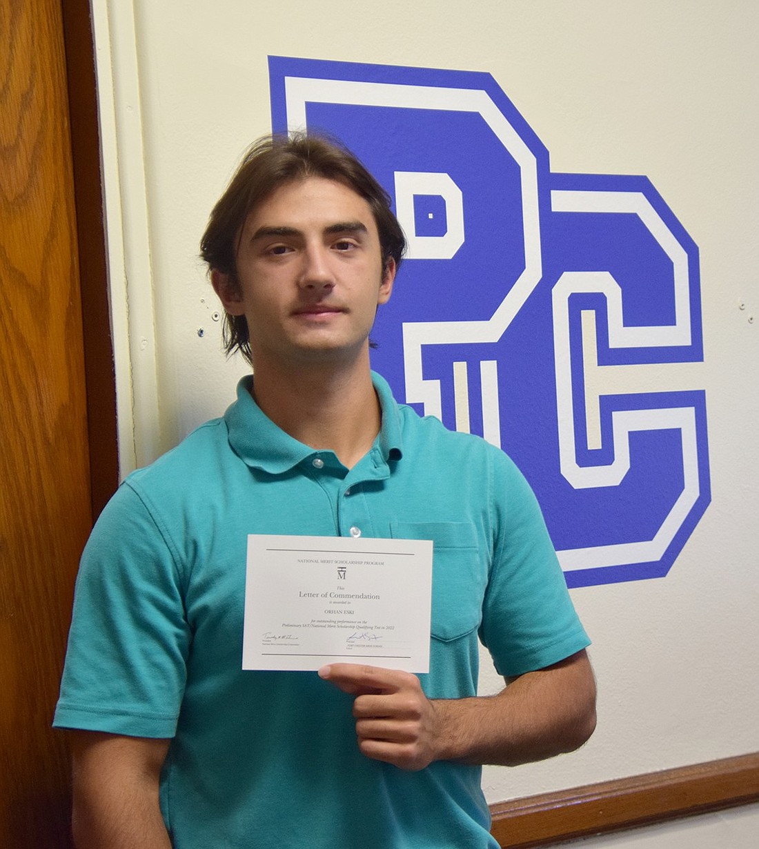 Port Chester High School senior Orhan Eski poses with his letter of commendation on Tuesday, Oct. 24. The letter, awarded by the National Merit Scholarship Corporation, honors him as one of the top 2% of scorers on the PSAT/NMSQT.