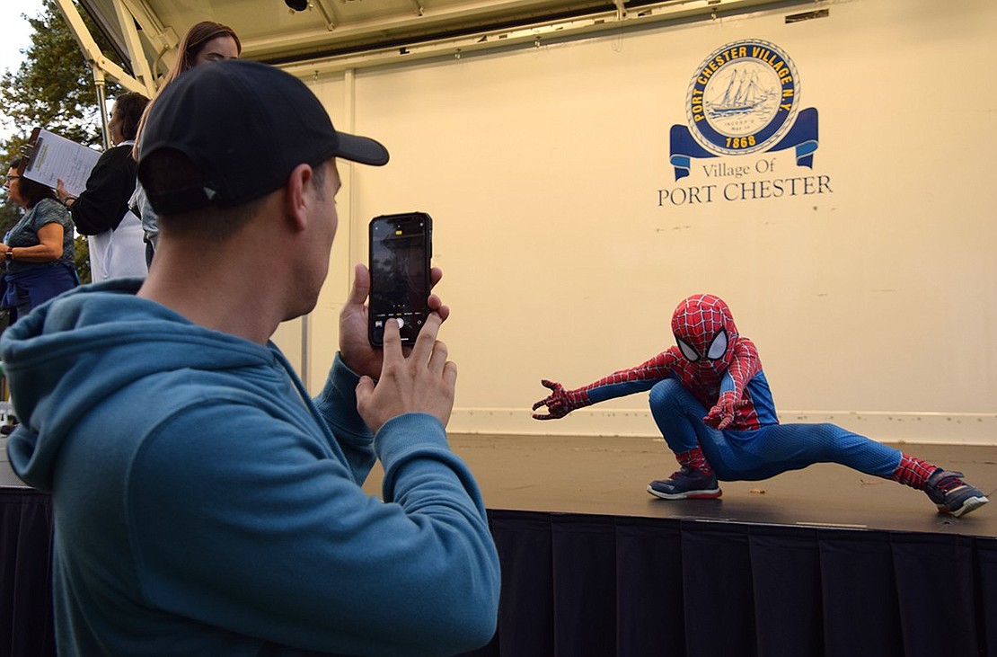 Port Chester resident Galo Rivas snaps a photo of Spider-Man, whose real identity is 6-year-old Galo Rivas Jr., on the stage set up for the costume contest.