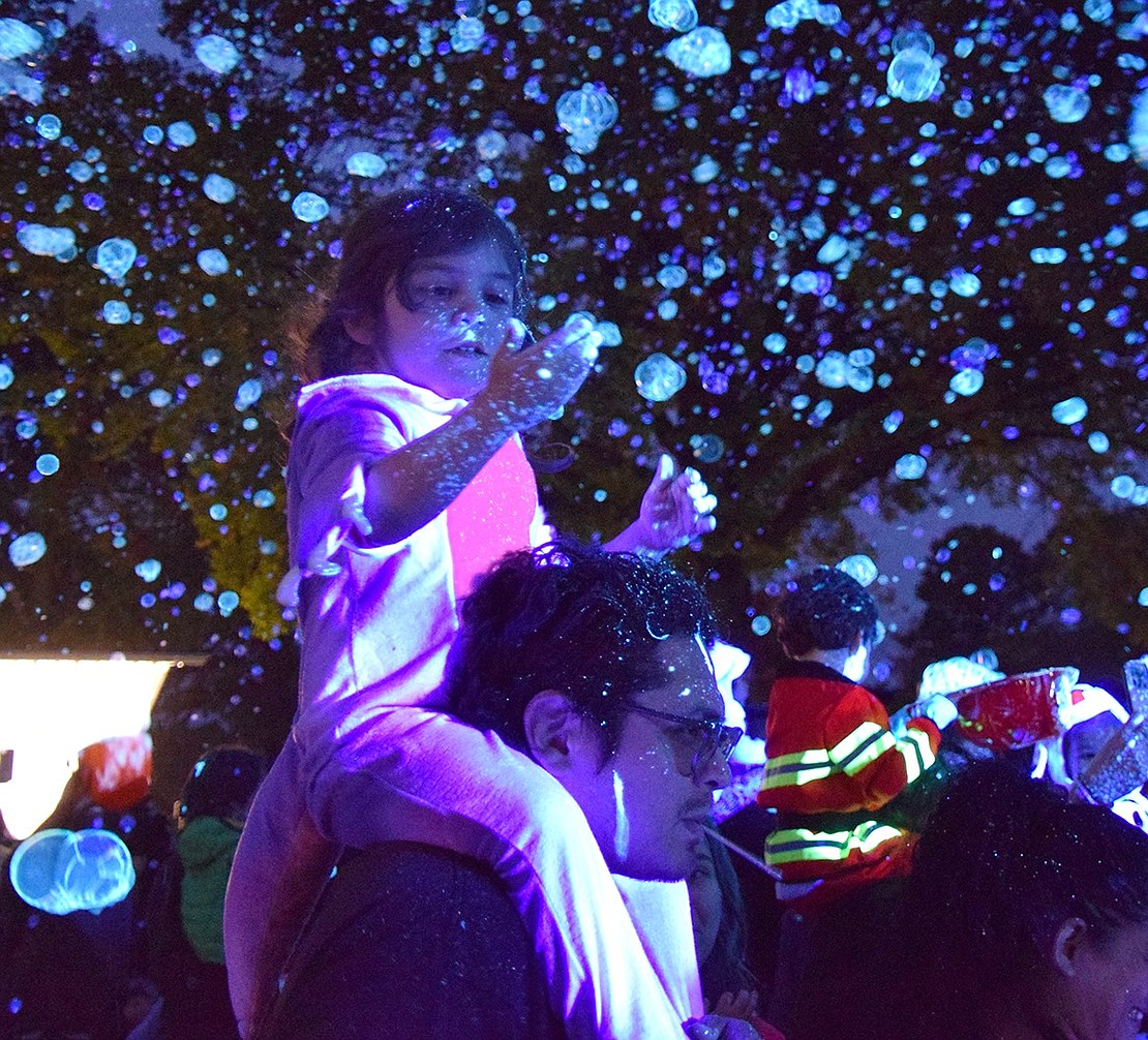 A glow-in-the-dark bubble party closes out the night, with Port Chester resident Claire Diaz enjoying it on the shoulders of her father, Bryan.