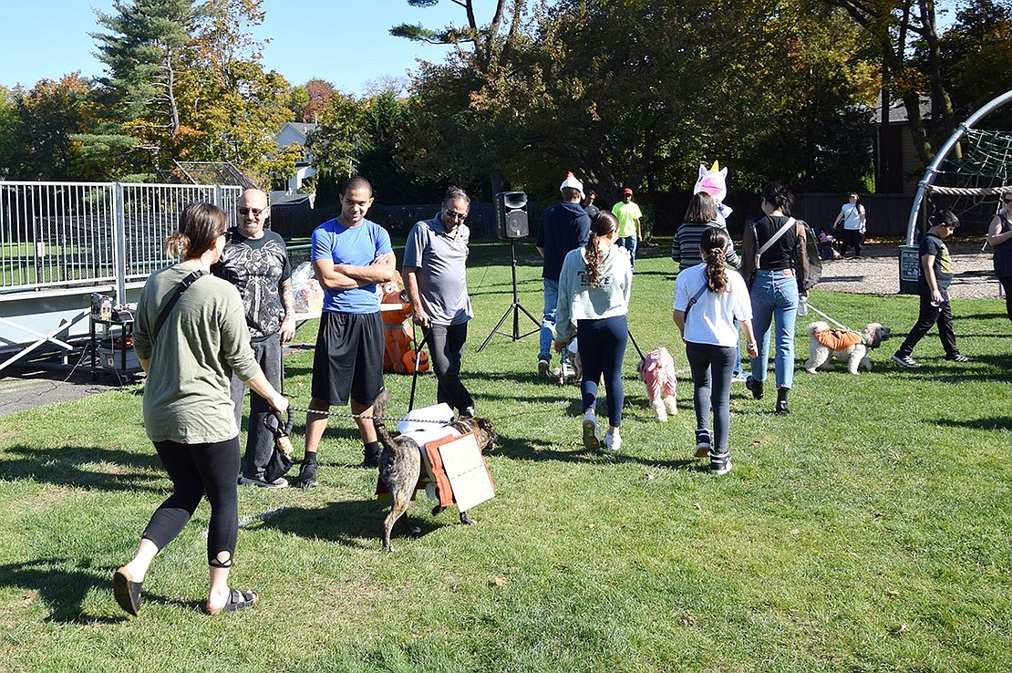 Dogs do their final lap around the park as judges Michael Carrieri (left), Greg Rivera and Sal Morlino get their last looks at them.