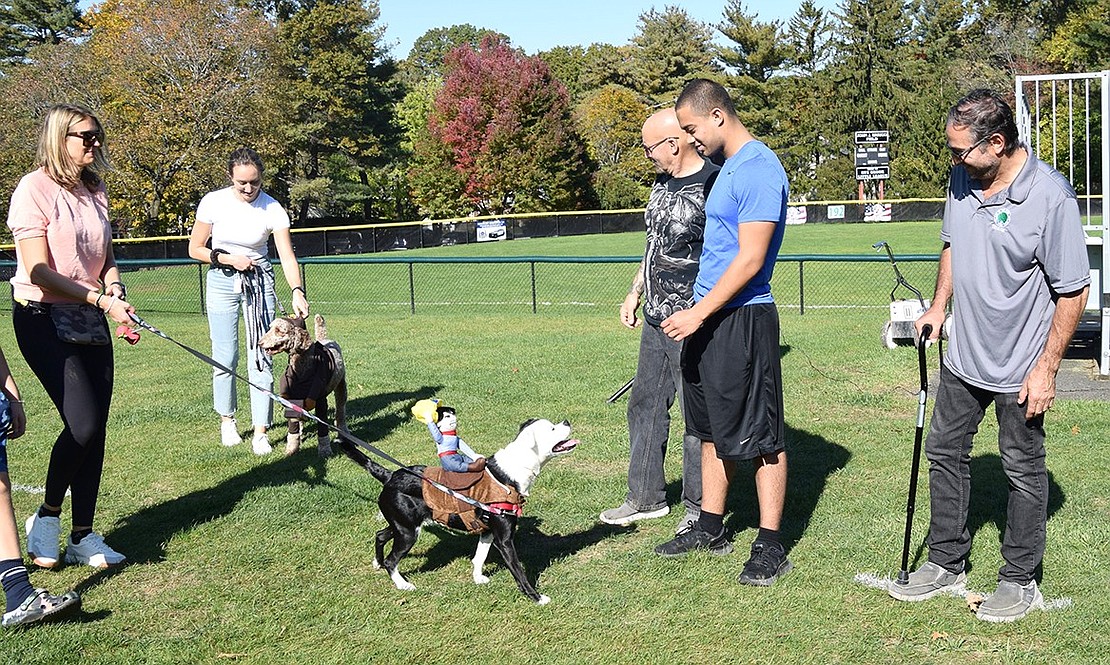 Serving as a cowboy’s loyal steed, 1-year-old Delilah, a mixed breed rescue, soaks up the attention of judge Greg Rivera. Her owner, Kiki De Bari of Rye Brook (left), watches.