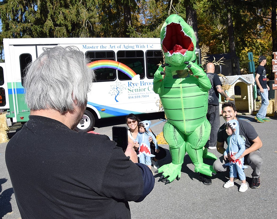 Valley Terrace resident Howard Lim Jr. takes a photo of his daughter Caroline and Tomas Virgadula, both based in New York City, as well as his twin 2-year-old granddaughters Evie and Julie Lim, who live on Valley Terrace, as they pose with a T-rex.