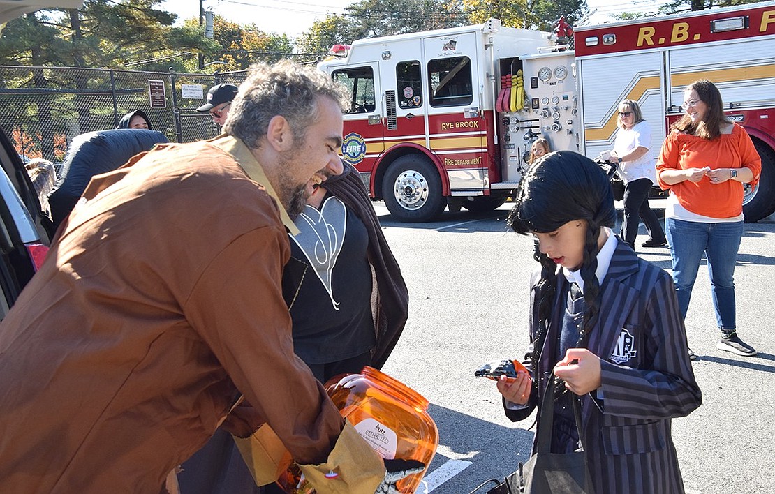 Ensuring he won’t get on the bad side of Wednesday Addams (also known as Ridge Street School fourth-grader Diana Pring), Rye Brook recreation assistant Rocco Furano gives her some pretzels.