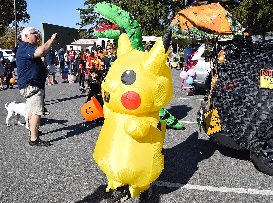 Dressed as the world-famous Pikachu, 6-year-old Oliver Andruk, a Ridge Street School first-grader, takes a look around at the vehicles in hopes of finding the best treats.