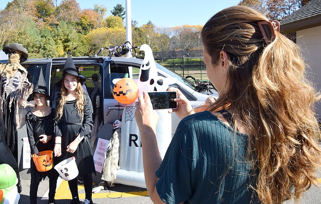 Originally from Israel, 9-year-old Yaren and 12-year-old Maayan take the opportunity to dress up for their first Halloween in their new community of Rye Brook during the Village’s inaugural Trunk-or-Treat event in Pine Ridge Park on Saturday, Oct. 28. Their mom, Sharon Sagher, takes a commemorative photo of the girls with the car decorated by the Rye Brook Recreation Department, which was voted most popular of the vehicles dispensing treats at  the event.