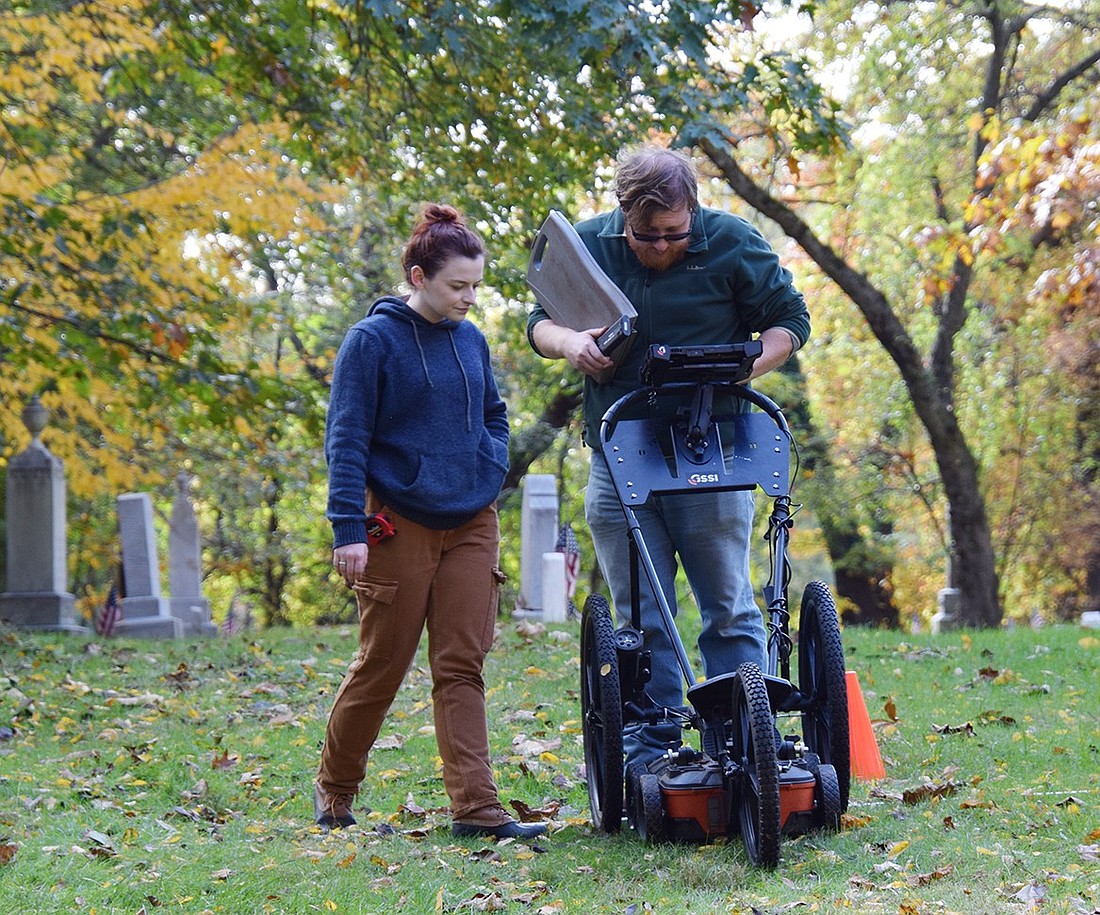 Geophysical specialists Fiona Jones (left) and Cole Peterson operate a ground penetrating radar machine at the African American Cemetery in Rye on Tuesday, Oct. 31. The survey is part of a larger project to accurately map out the plot, both above ground and beneath it, in an effort to preserve the history of the those buried there and find potential unmarked graves.