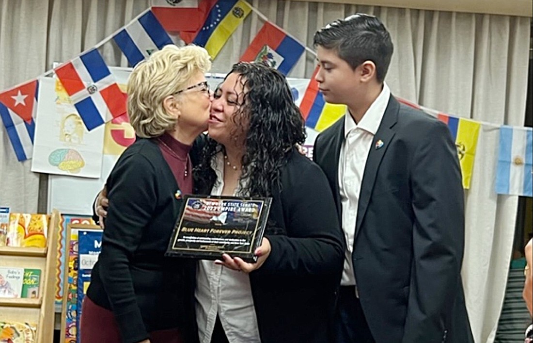 State Senator Shelley Mayer (left) presents Lynda De Gómez with a New York State Senate Empire Award on Oct. 19, as her 12-year-old son Julio watches with pride. De Gómez is the founder of the Blue Heart Forever Project, a parent support group she operates which primarily helps families who have children with autism or require some form of special education.