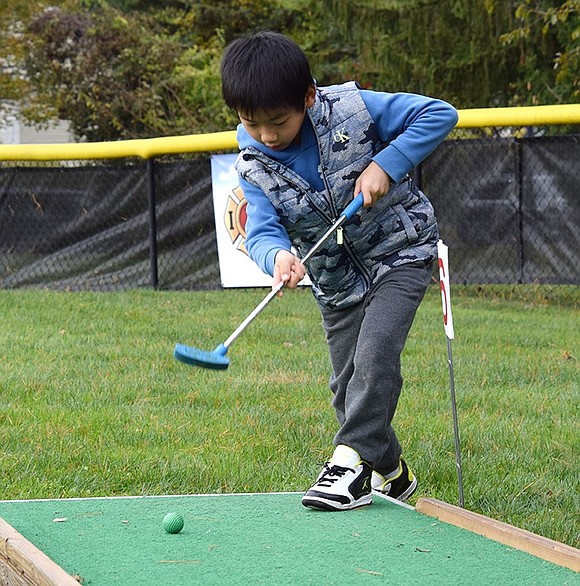 Conner Wu, a first-grader at Ridge Street School, takes his shot on the sixth hole at the Family Mini-Golf event on Saturday, Nov. 4 at Pine Ridge Park. Hosted by the Rye Brook Recreation Department, the new activity allowed families to practice their putting skills on the greens.