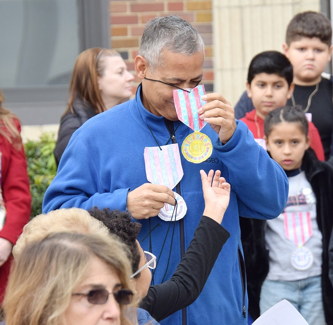 U.S. Navy veteran and Port Chester resident Miguel Villafane, who served as a radioman from 1980 until 1984, puts on one of the several medals that were given to him.
