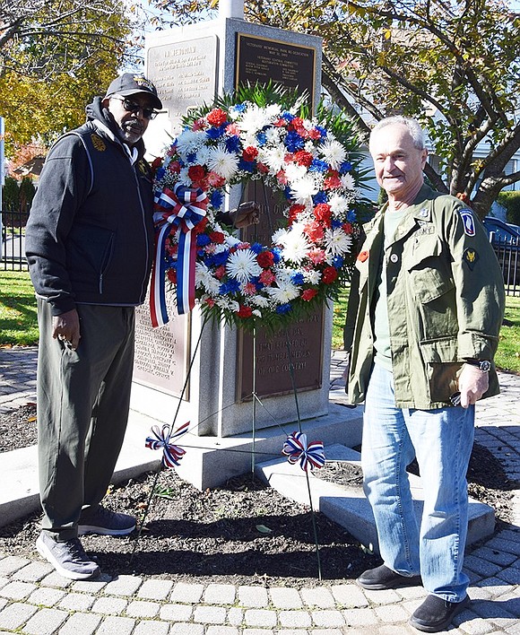 Vietnam veterans Fred Griffin (Coast Guard) of Field Place and Steve Vespia (Army) of Argyle Road place a memorial wreath at the flagpole monument recognizing local veterans who died during World War II and the Korean War, with a special memorial for the 8 Willow Street Boys who gave their lives in WWII.