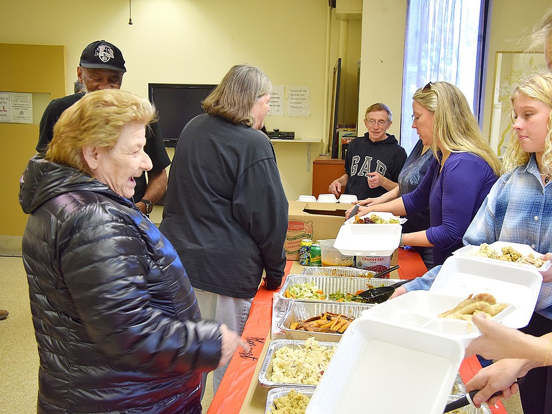 Donna Herring (left), a resident of 10 Drew St., asks for a serving of mashed potatoes to be included in her dinner.